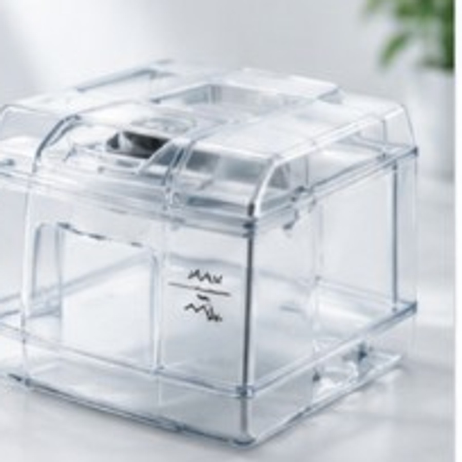 Transparent CPAP humidifier water chamber on a bright surface