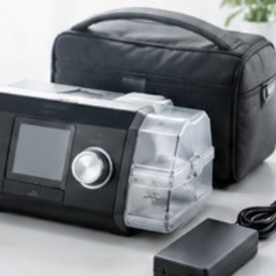 CPAP machine with humidifier chamber, power adapter, and travel case