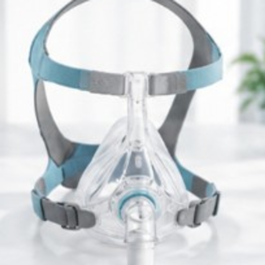 CPAP mask with headgear on a bright white surface