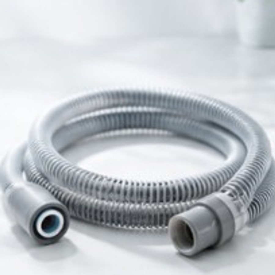 Coiled CPAP tubing with connectors on a clean white surface