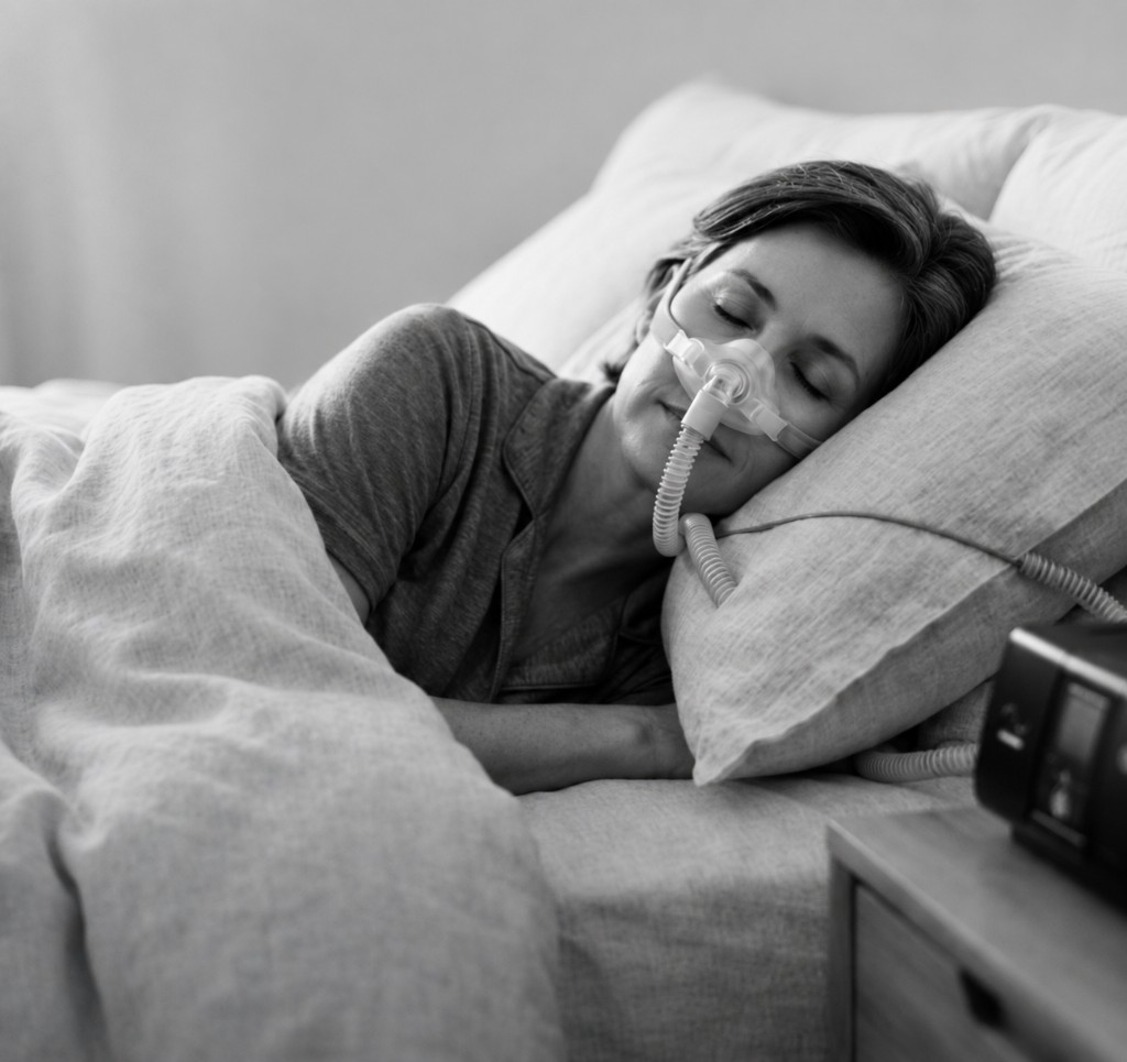 Person resting comfortably with a nasal CPAP mask
